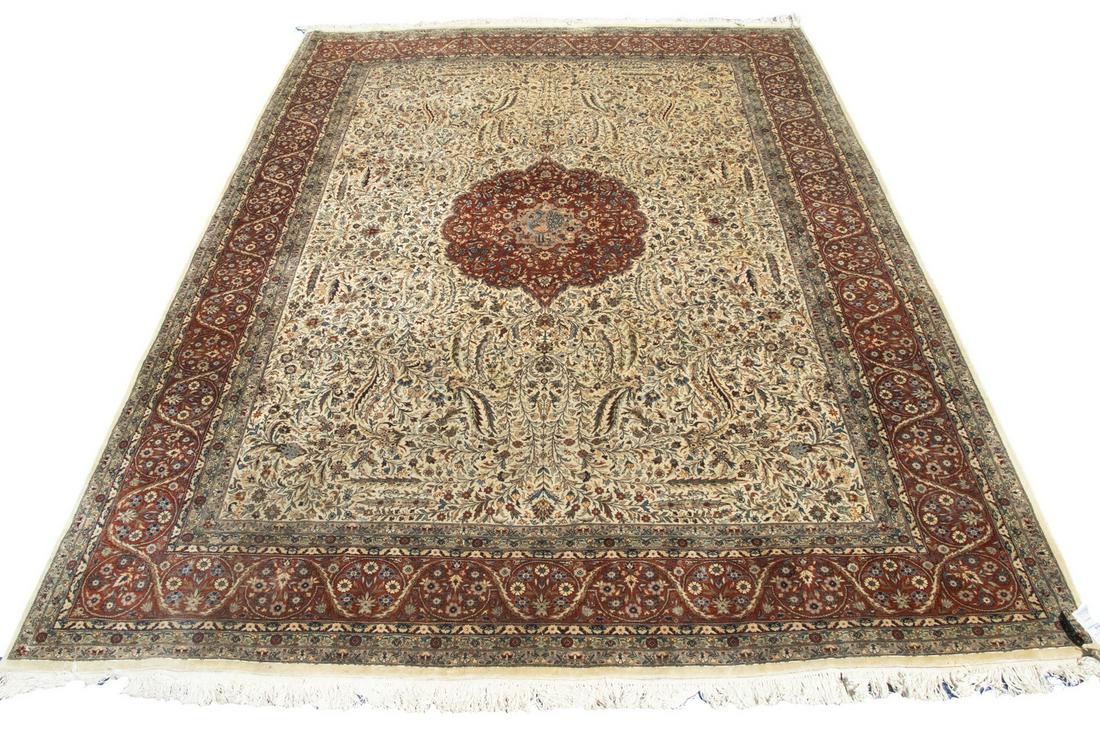KASHAN CARPET (9' X 12'6"): Lobed circular medallion with pendants in rust, sky and midnight blue, and gold on the floral filled ivory field with a rust vine rosette and palmette border. Overall good pile with some minor moth da