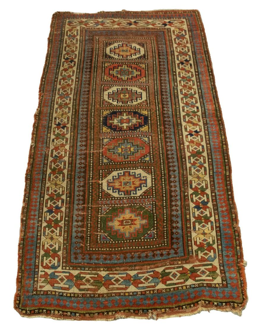 KAZAK RUG (4' X 7'10"): Southwest Caucasus, late 19th c. A column of seven octagonal medallions, each inset with polygons in gold, rust, sky and midnight blue with a gold octagon border. Crease wear, corner, salvage and end 