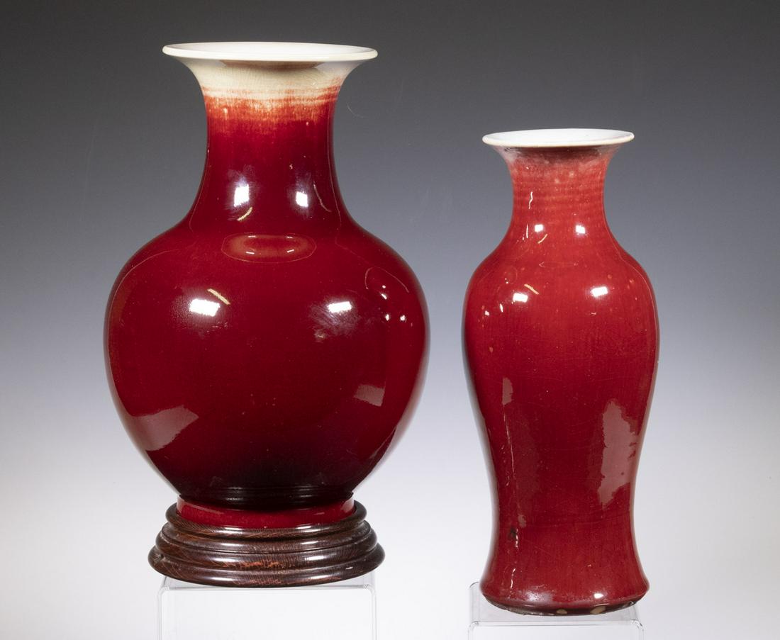 (2) CHINESE SANG DE BOEUF GLAZED VASES: Both Baluster Form, flared rims, incl: Early 20th c. bulbous vase, with wooden stand, 11" high (without stand), 6 3/4" diam.; and mid-20th c. vase, with flared base, 11" high, 4 1/4" diam. Both with d