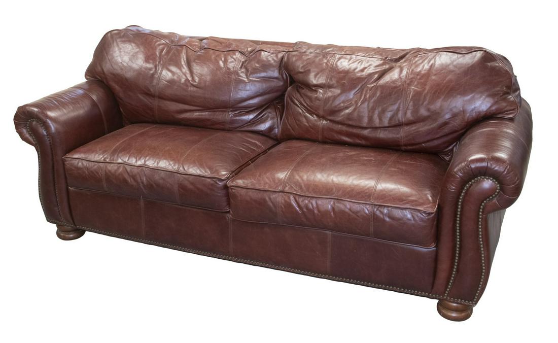 THOMASVILLE BENJAMIN LEATHER SOFA: Brown Leather Upholstered Double Cushion Sofa, with semi-attached back cushions, removable seat cushions with top stitching and self cording, rolled arms with brass tacks, set on compressed ball form