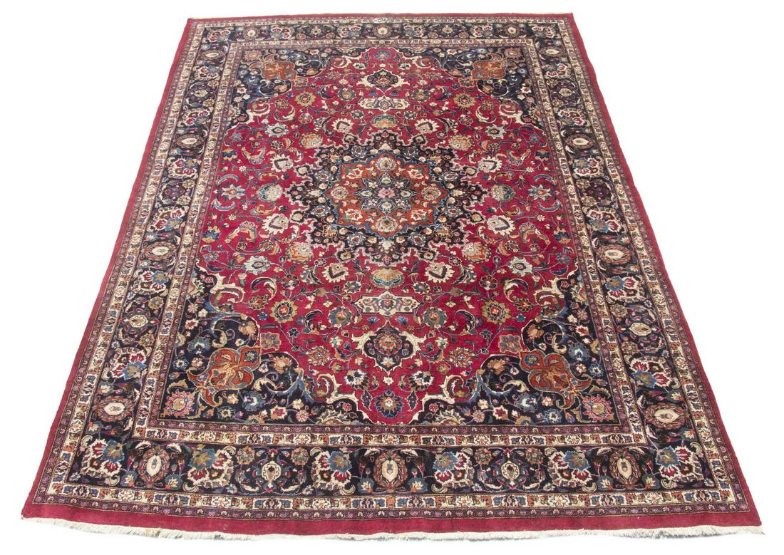 KASHAN CARPET (9'3" X 12'8"): West Central Persia, mid-20th Century manufacture. Featuring a vibrant rust and midnight blue rosette medallion with matching pendants and spandrels surrounded by flowering vines and palmetes in ivory