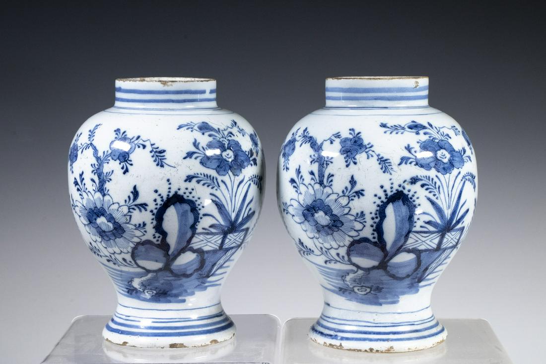 PR 18TH C. DELFT VASES: Pair of Dutch Blue & White Tin Glazed Earthenware Vases, ovoid shape with flared foot, painted floral decoration, unmarked, 7 1/8" high, 5 1/2" diam. Rim and base edge glaze frits; one with large re-g