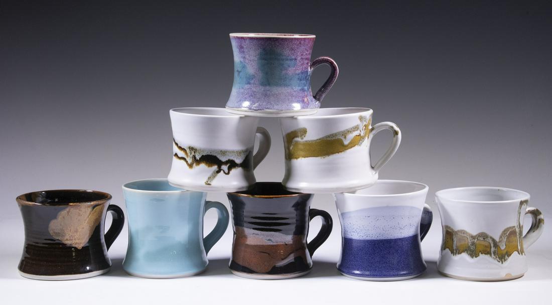 BROTHER THOMAS BEZANSON (CANADA/VT, 1929-2007) ART POTTERY MUGS: Collection of (8) Mugs, variety of glaze treatments, waisted shape and applied handles, all with Bezanson's cipher mark on base, 3 1/2" to 4" high. Good condition.