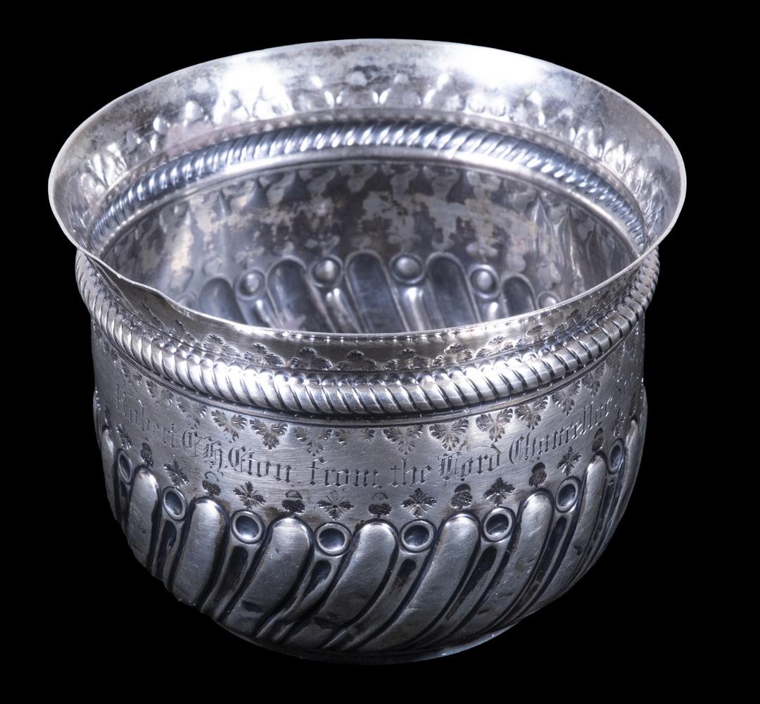 VICTORIAN SILVER VESSEL WITH LORD CHANCELLOR PRESENTATION: English Sterling Silver Repousse Decorated Cup or Bowl, with inset 1787 silver shilling coin in base, London 1890 hallmarks by silversmith Charles Stuart Harris, with engraved presentation "Robert Ch.