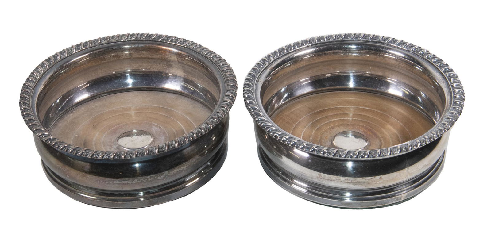 PR SILVER-PLATE WINE COASTERS: Pair of Sheffield Silver on Copper Bottle Coasters, turned mahogany bases, gadrooned rims, felted undersides, 2 1/4" high, 6" diam. Minor silvering losses.