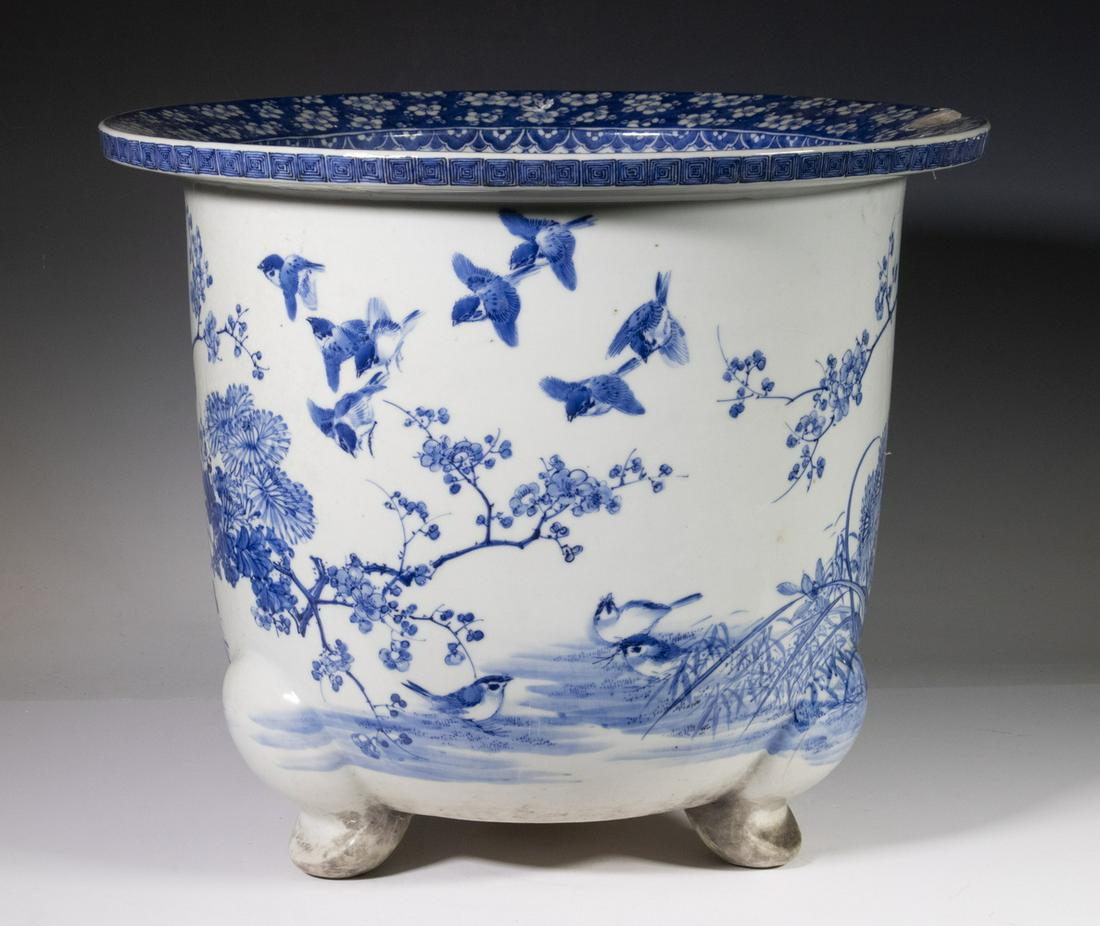 JAPANESE BLUE AND WHITE JARDINIERE: Large Meiji Period Porcelain Footed Jardiniere, with floral decoration, set on three curved legs, 14 3/4" high, 17 7/8" diam. Large rim chip.