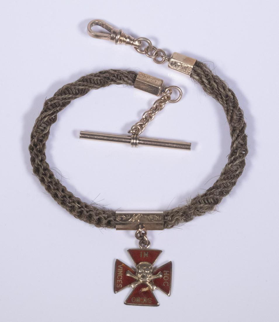 GENT'S WATCH CHAIN: c. 1860. Woven from human hair with engraved 10K gold fittings and a Masonic Medal fob. 11" long. Condition: chip on fob enamel and wear to hair weave near center.
