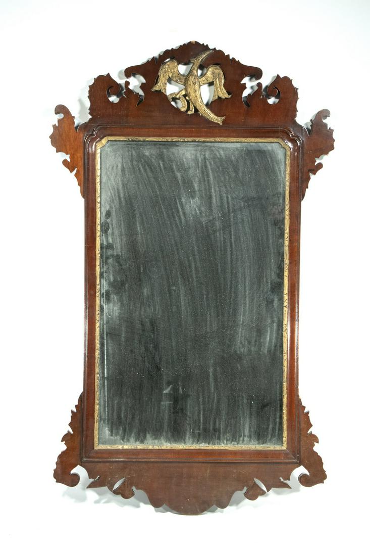 CHIPPENDALE MIRROR: Mahogany Early 20th c. Chippendale Style Mirror, with inset gilded phoenix bird, shaped crest, ears and base, gilded inner lip, heavy wooden back panel, 39 1/2" x 23 3/4". Surface wear and scratches, 