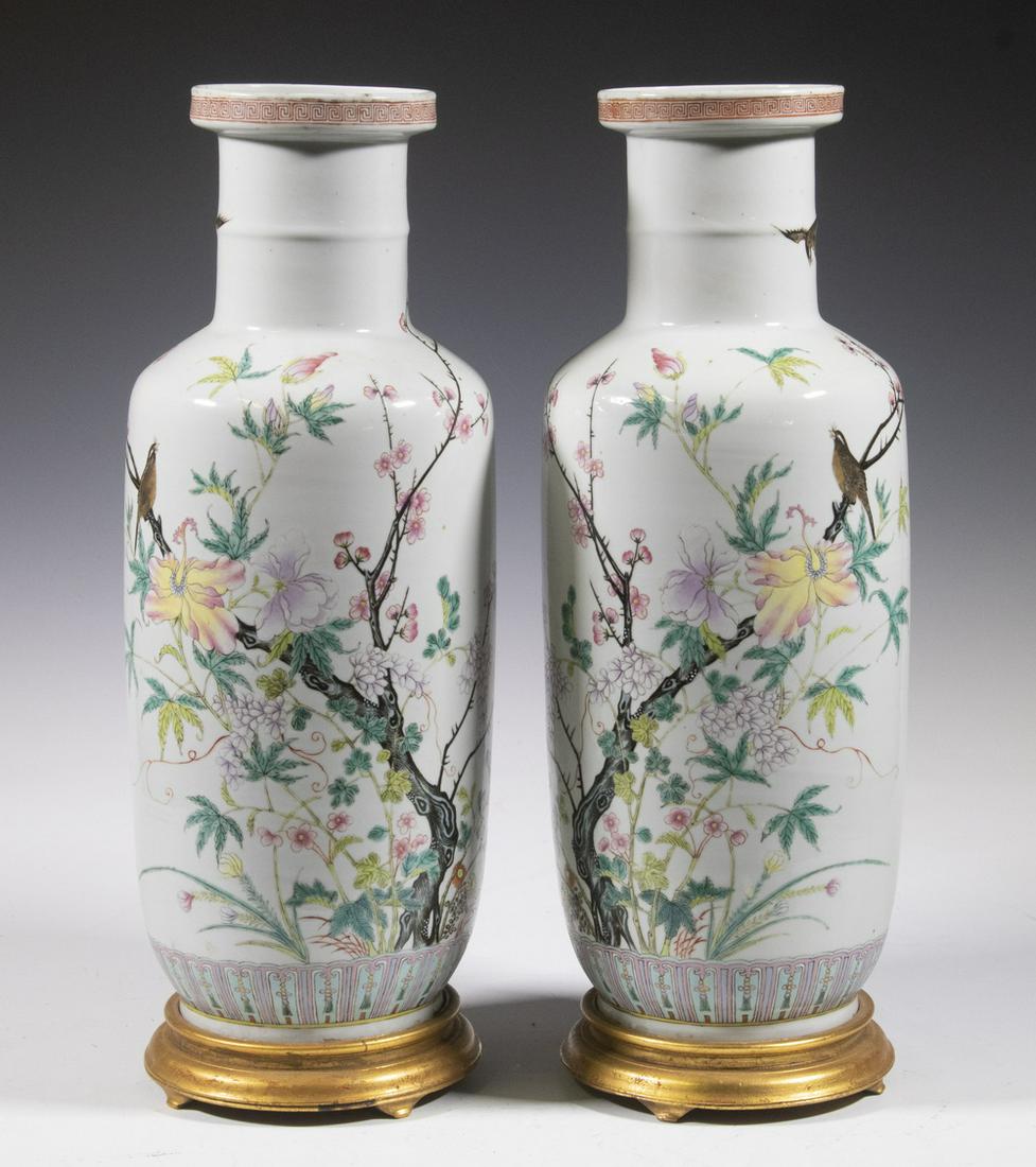PR CHINESE PORCELAIN VASES: Pr of Famille Rose Baluster Form Vases, with enameled bird, floral & butterfly decoration, meander decorated rim and lappet base edge, with gilded wooden stands, vases only: 17" high, 6" diam. Drilled
