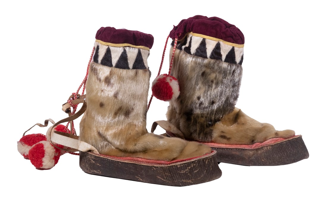 PAIR SEALSKIN SHORT BOOTS, ALASKA INUIT: Rawhide soles, red & white wool cords and poms, fur-lined soles, wine corduroy cinch tops with decorative band just below. 11" long.