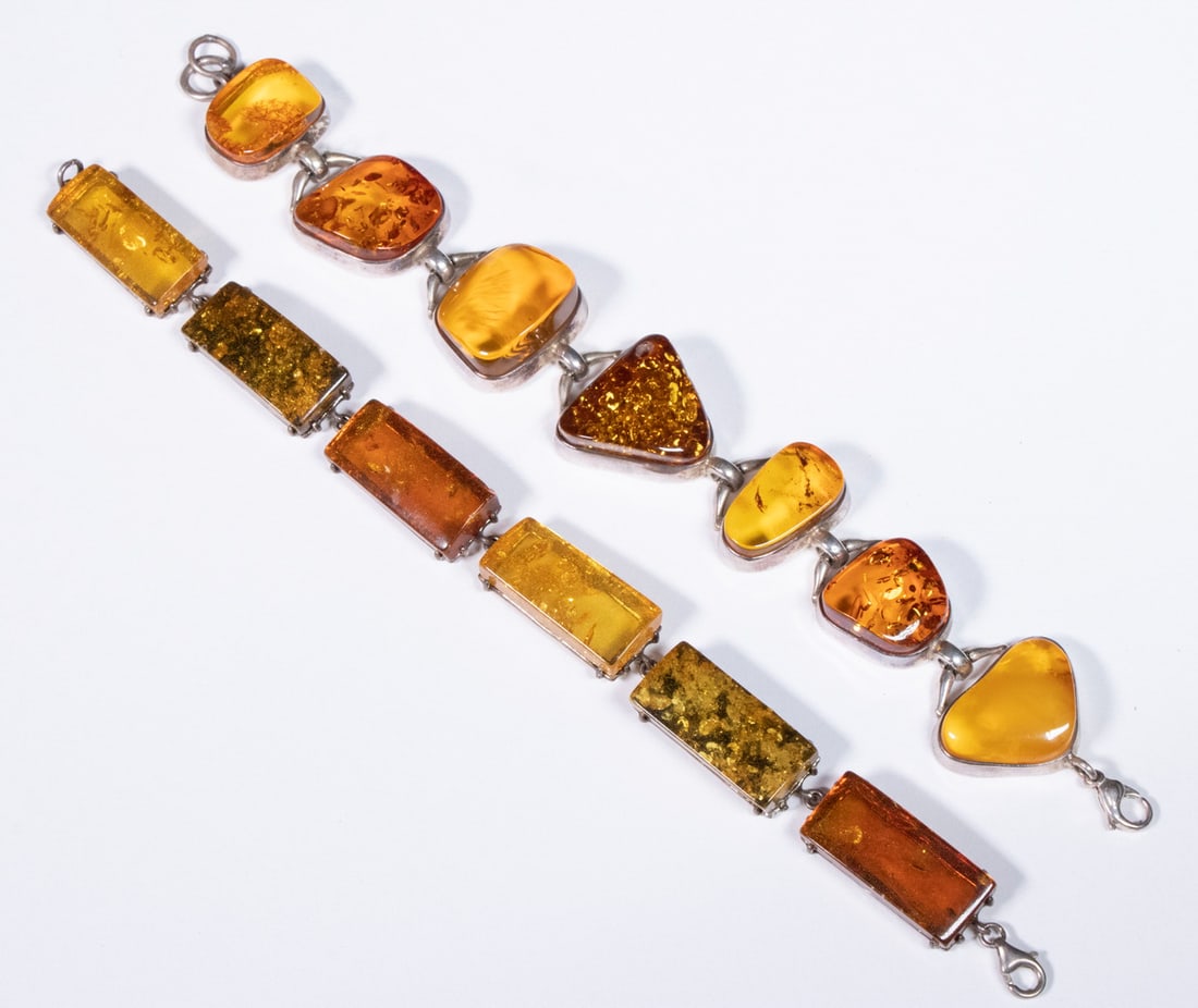 AMBER LINK BRACELETS: Lot of (2) Silver Mounted Link Bracelets set with polished amber, 1" wide, 8" long and 1/2" wide, 8" long.