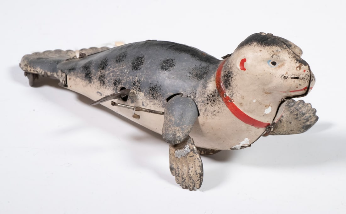 LEHMANN TIN LITHO WIND-UP SEA LION TOY: Early 20th c. "Performing Sea Lion" or Seal Toy by Lehmann Toys, DRGM, made in Germany, with key, marked to underside of tail, 2 3/4" high, 7 1/2" x 4 1/4". Key wind motion mechanism works, but front 