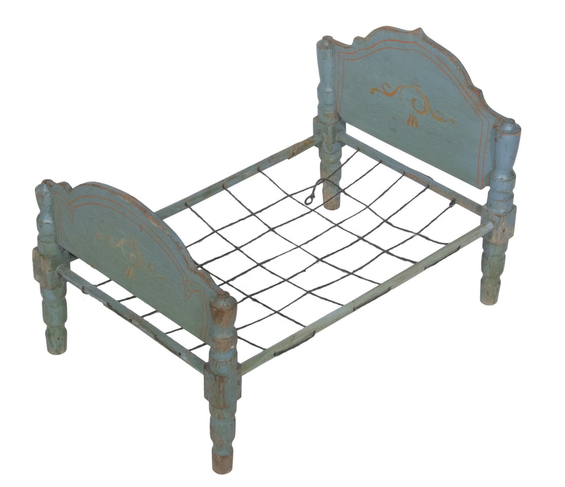 BLUE PAINTED DOLL BED: Vintage Wooden Doll Bed, shaped headboard and footboard with red painted decoration on blue ground, turned posts, woven twine support, 16 1/4" high, 24" x 15 3/4". Paint losses, one side rail break (g