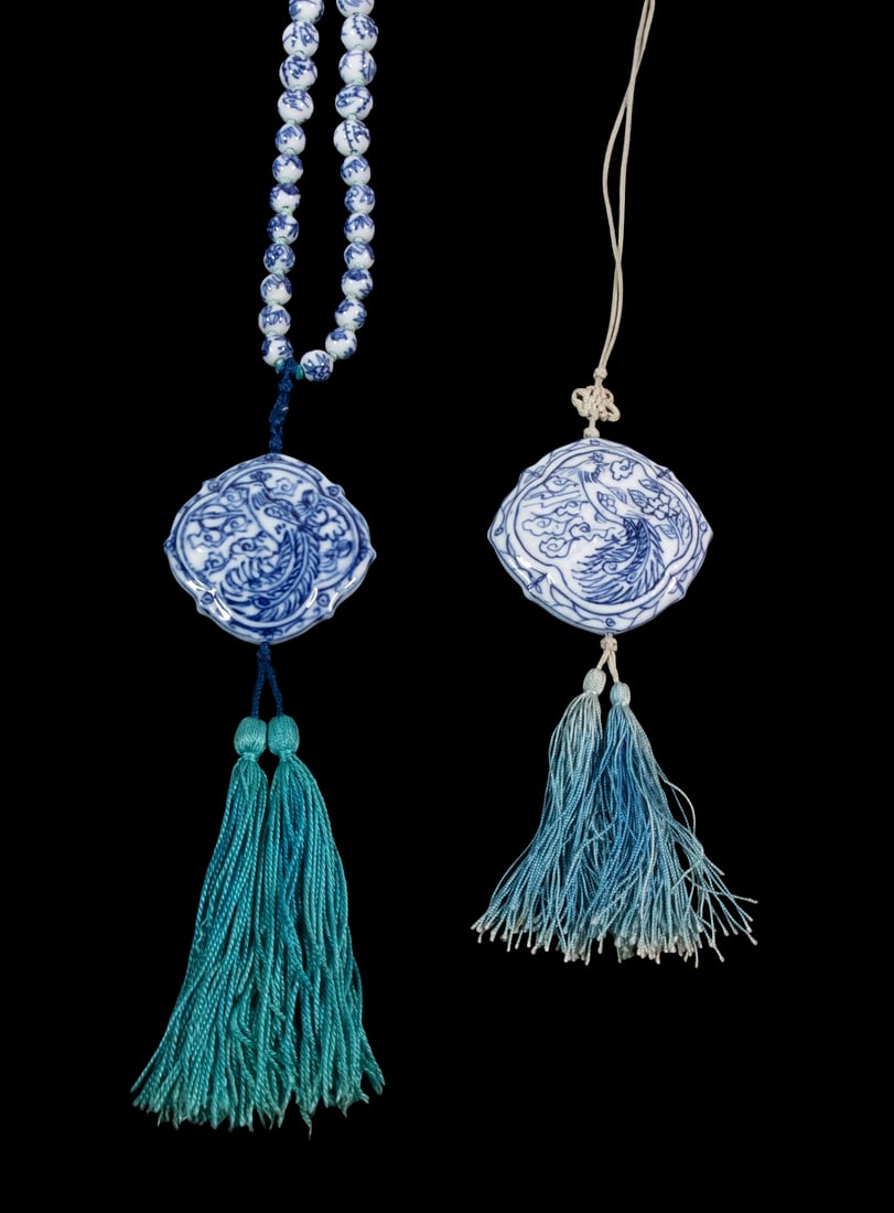 CHINESE PORCELAIN NECKLACES: Lot of (2), incl: Necklace of graduated blue and white porcelain beads and large drop pendant with image of a peacock, with silk tassel, beads only: 28" long, pendant with tassel: 7 1/2" long; and Sil