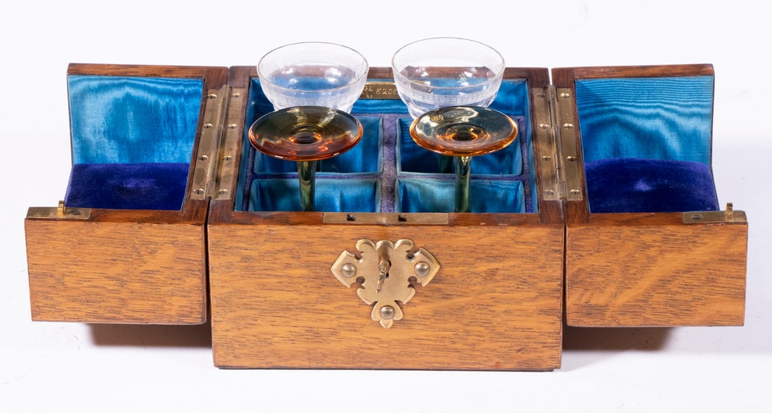 ENGLISH OAK CASED TRAVELING STEMWARE SET: Set of (4) Crystal Cordial Glasses, in a ca. 1900 brass mounted oak fitted case with blue satin and velvet lining, with double hinged top, with key, 5" high, 5 3/4" sq., each glass: 3 1/4" high. Tight