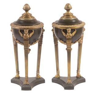 PR EGYPTIAN REVIVAL BRONZE URNS: Pair of French Lidded Tripod Urns, late 19th c., in gilded and patinated bronze, each leg topped with a bust of the god Horus, with paw form feet, set on patinated bronze bases, underside of bowls sta