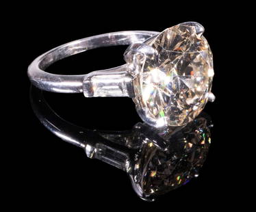 VINTAGE 18K WHITE GOLD DIAMOND RING: Ca. 1920 ring set with 6.54ct (by calculation) Circular Brilliant cut Diamond. Clarity SI-2, Color Q-R. (2) Diamond baguettes on sides. Clarity CS, Color G-H. Size 6 3/4. 4.43dwt. Good condition, has