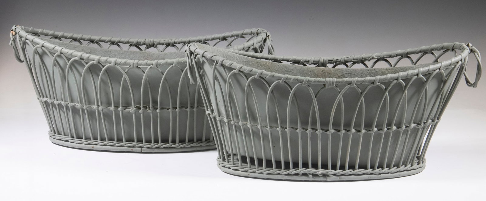 PAIR OF FRENCH STYLE CHAMPAGNE COOLERS: In rattan with fiberglass liners, having ring handles on each end, painted in flat grey-green, 9" x 19" x 8 1/2" each.