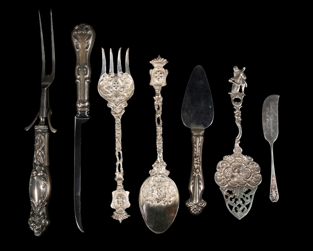 ASSORTED SILVER & SILVER-PLATE UTENSILS: (7) Piece Lot, incl: German 800-silver figural serving spatula, handle with man playing a cello, blade with image of two children, 7" long; Gorham sterling flat handle spreader knife, blade engraved "