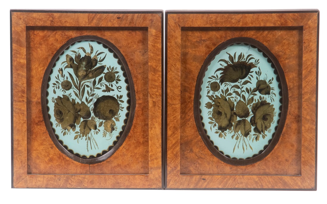 PAIR OF ENGLISH GILT REVERSE GLASS THEOREMS: Posies of Blossoms in black on gold with cream field, oval, with scalloped edge, housed in rectangular burl sunburst veneer frames, retaining the original backings and ring hangers, with tag from Chri
