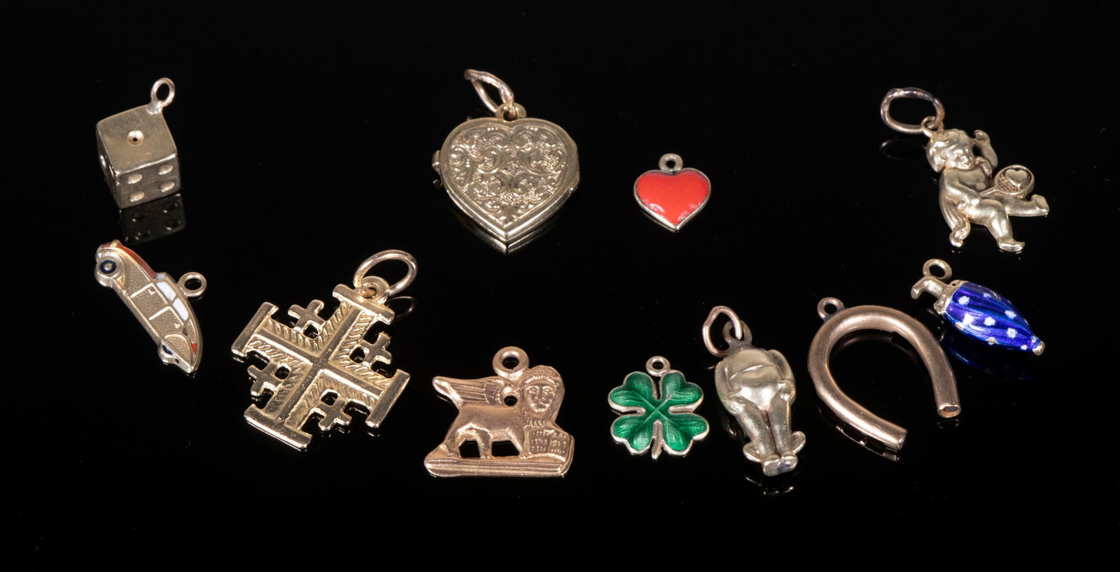 (11) ASSORTED GOLD CHARMS: Collection of Charms, in 14K and 10K gold, some with enameling, including a hinged heart shaped locket, 1/4" to 7/8" long, 5.1 dwt tw.From the Estate of 19th C. Actress Jenny Gross