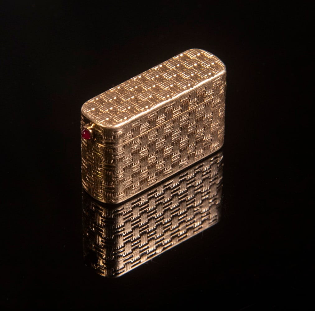 TIFFANY & CO. GOLD BASKETWEAVE PILL BOX: 14K Yellow Gold Hinged Top Box, with cabochon ruby clasp, 3/4" high, 1 1/4" x 1/2", 12.2 dwt tw.