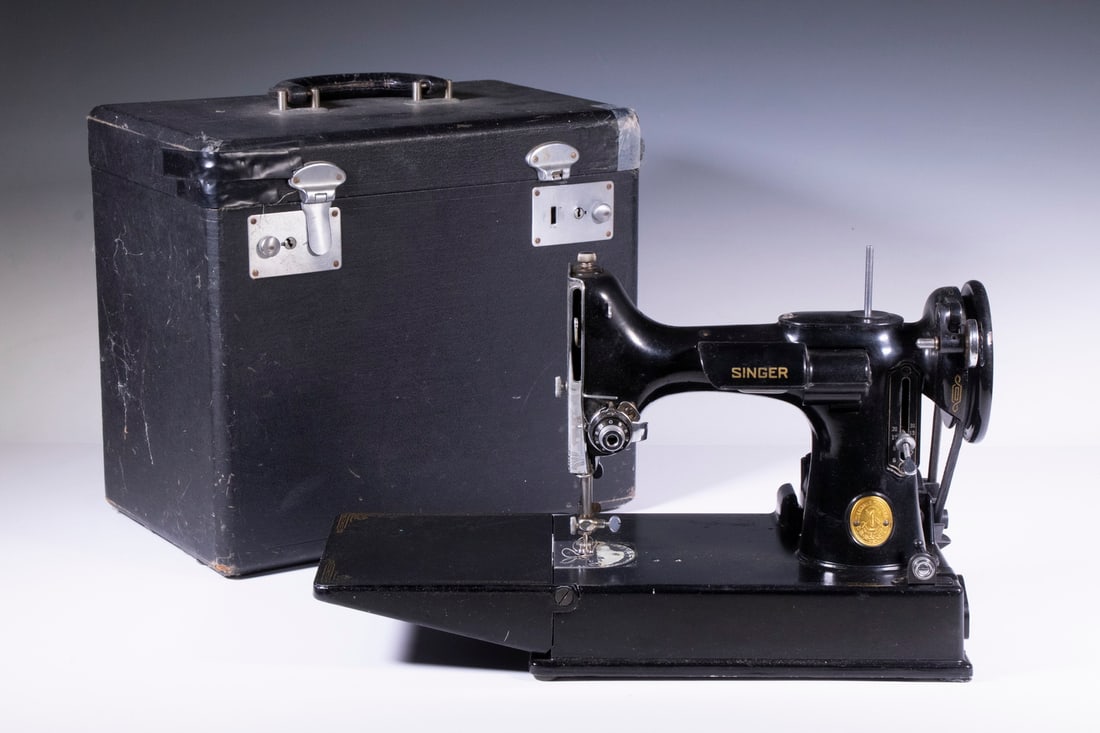 SINGER FEATHERWEIGHT SEWING MACHINE: Cased Model 221-1 Portable Sewing Machine, sn AH199223, 1947, with foot control, original manual, bobbins and attachments, and extra needles, case: 12" high, 13" x 8".