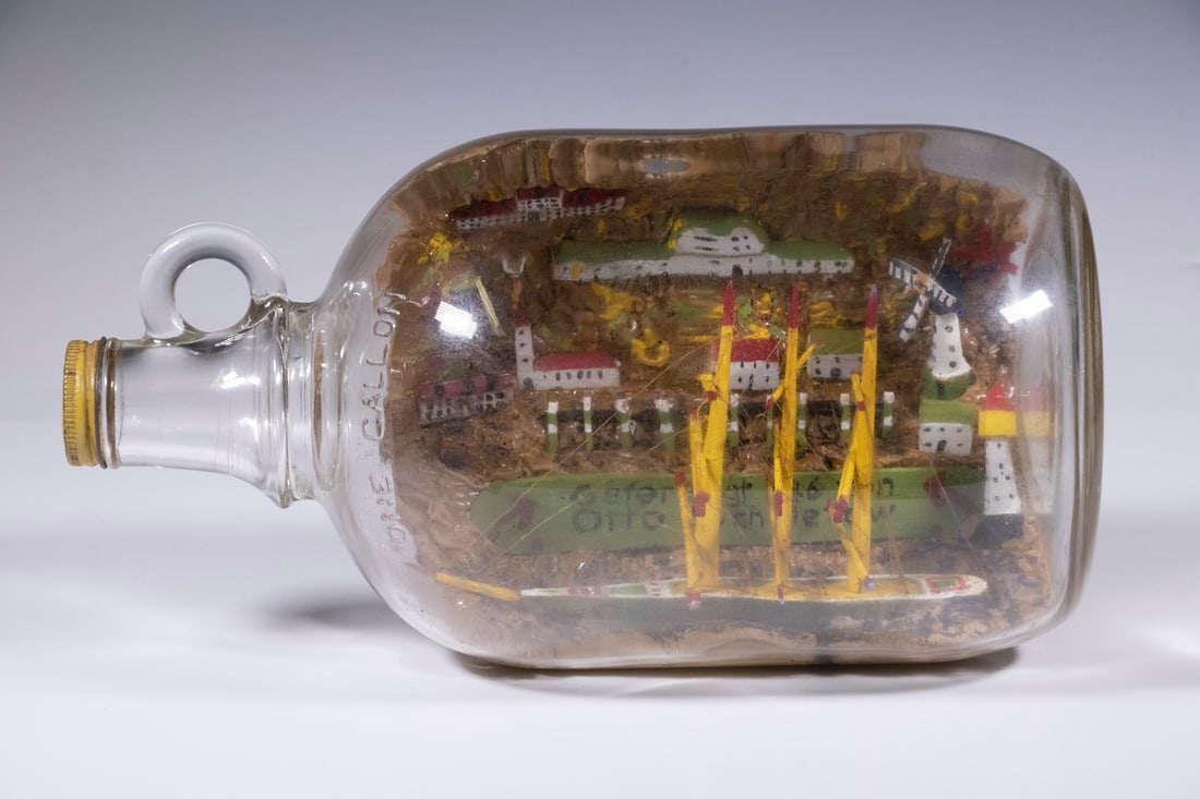 VINTAGE SHIP-IN-A-BOTTLE: Hand Crafted Wooden Three-Mast Ship, in a one-gallon bottle with painted three-dimensional dock and harbor town plaster of Paris background, dock painted in German "Gefertigt 1946 von Otto Schmietow"