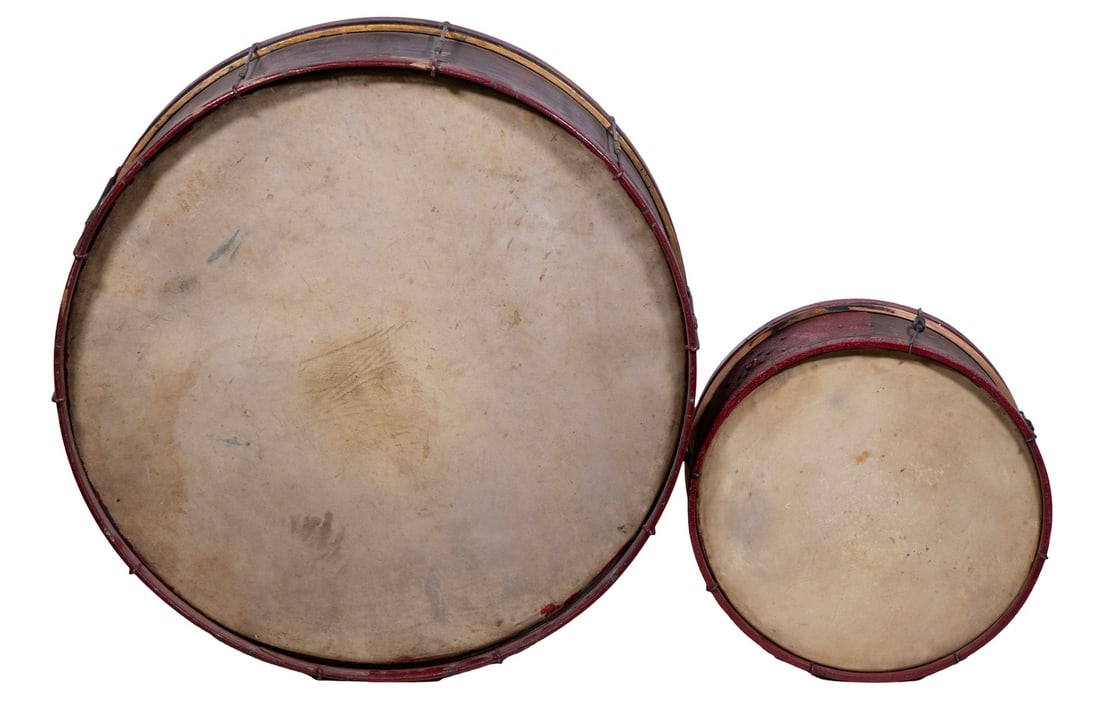 WOODEN BASS & KETTLE MARCHING DRUMS, CIRCA 1880: Unmarked, walnut veneer body, wine red painted rims, vintage skin drum heads, 12" x 29" diam & 7 1/2" x 16" diam, one head gone from each.