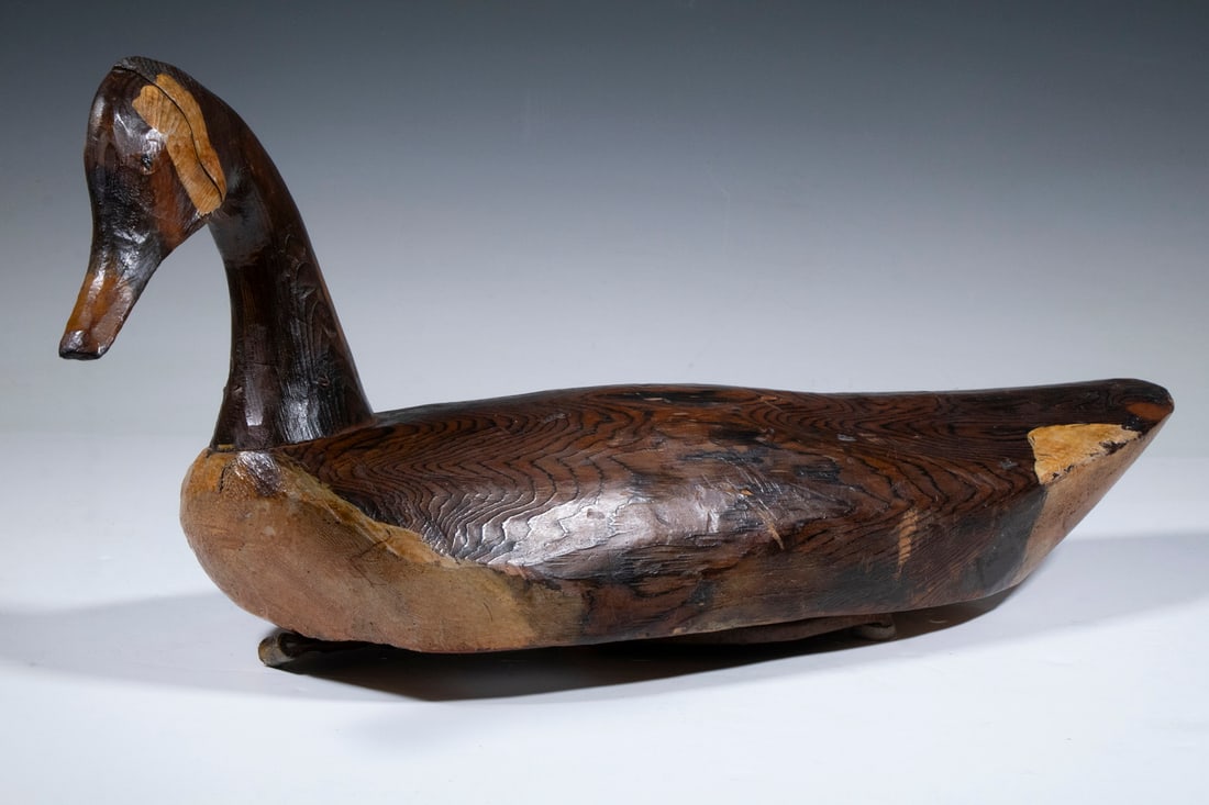 CANADA GOOSE DECOY: 19th c. Carved and Painted Working Decoy, with tilted head, horseshoe weight affixed to underside, unsigned, 10 1/2" high, 23 1/2" wide. Head separation.