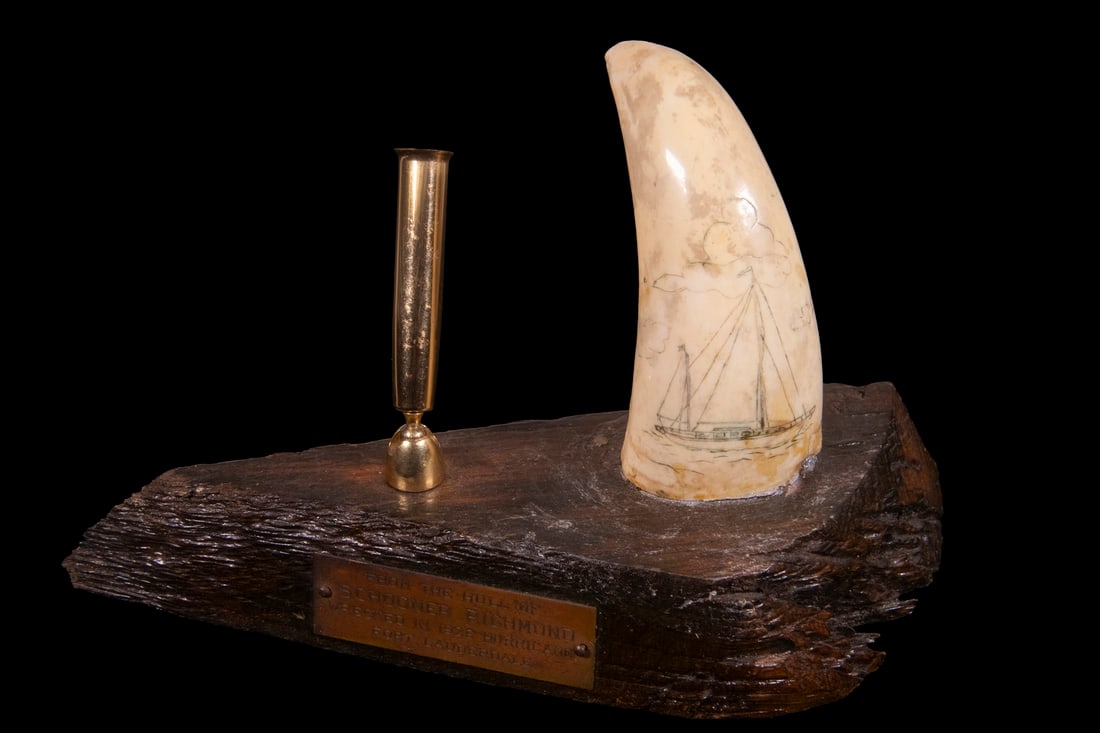 SCRIMSHAWN WHALES TOOTH AS PEN HOLDER: Commemorative Pen Holder with scrimshawn tooth depicting a schooner, mounted on a fragment of wood with brass tag that reads "From the Hull of Schooner Richmond, wrecked in 1926 hurricane, Fort Lauder