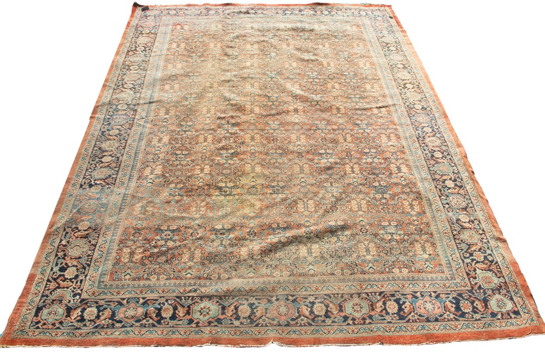 HERIZ CARPET (9'8" x 13' 6"): Northwest Persia, 2nd quarter 20th Century. Overall design of flowering vines, trees, and palmettes in midnight and sky blue, rust, tan-gold, blue-green, and red, on the rust field. Midnight blue "tur
