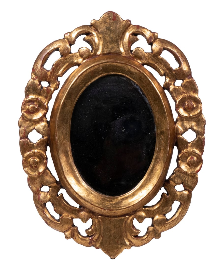SMALL OVAL 18TH C. ITALIAN GILTWOOD COURTING MIRROR: Oval reticulated leaf and scroll frame, watergilt, with replaced glass, 12" x 9".From the Estate of Bowdoin Professor William Collins Watterson.