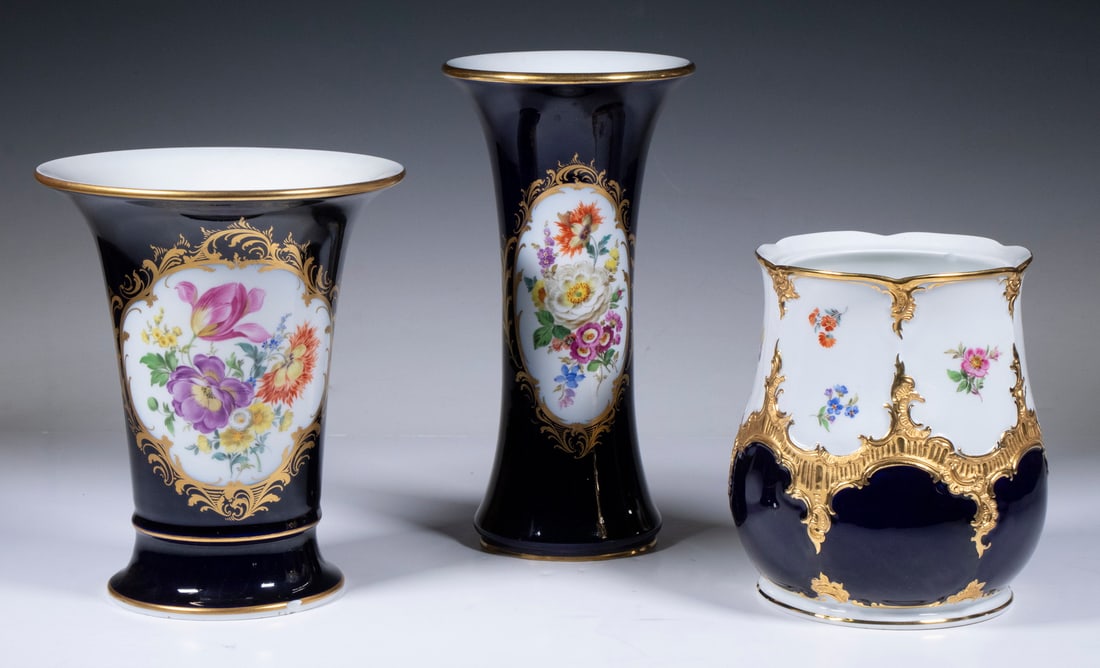 (3) MEISSEN HAND PAINTED PORCELAIN VASES: Group of (3) Vintage German Vessels, mid-20th c., all with reserves containing floral decoration and gilded highlights on a cobalt blue ground, underglaze blue crossed swords mark on base, including a