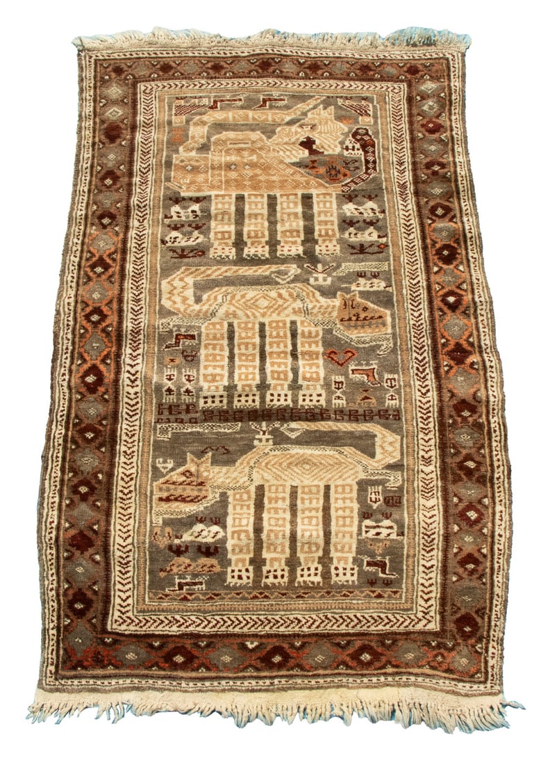 AFGHAN FIGURAL RUG (2'9"x4'5"): Afghanistan, mid-20th century, a column of three dogs in camel, ivory, and aubergine, flanked by small dogs and sheep, on the brown field, with a brown polygon border.Good condition.