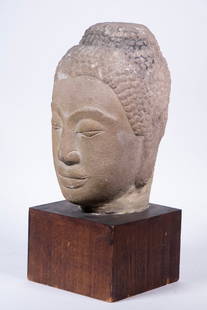 THAI STONE BUDDHA HEAD: Early Carved Sandstone Head of Buddha with pacific expression, mounted on rosewood base, scuffs.From the private collection of Sally Jessy Raphael Converted dimensions: 14 x 6 x 6 in. (35.6 x 15.2 x 1
