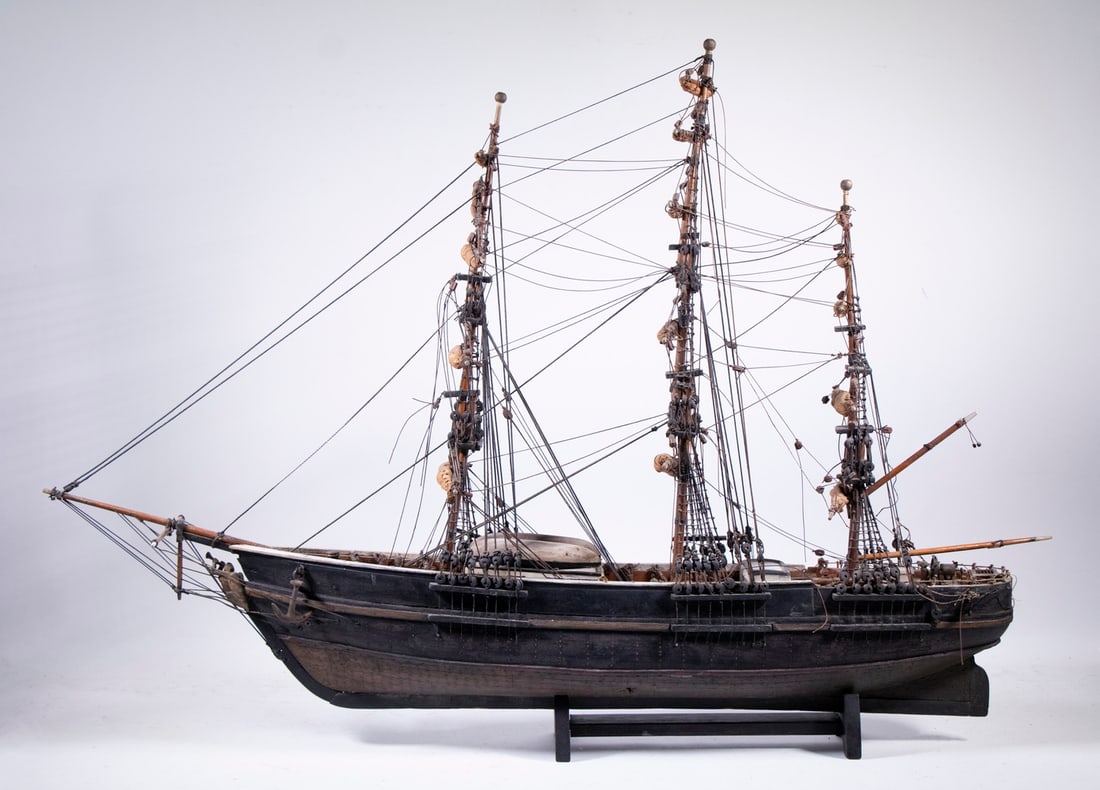 19THC. SAILOR-MADE MODEL OF WHALING SHIP: Barkentine Rigged Sailing Ship with two longboats on top of the rending hutch, black hull with copper bottom, fully rigged, with sails stowed, loose on original cradle. Converted dimensions: 27 x 37 x