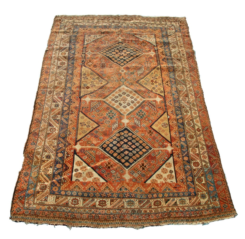 QASHQAI RUG (5'x7'6"): Southwest Persia, 2nd quarter 20th century, three diamond medallions inset with diamonds and rosettes, in midnight blue and taupe, flanked by rosettes and geometric motifs, on the rust field, with a r