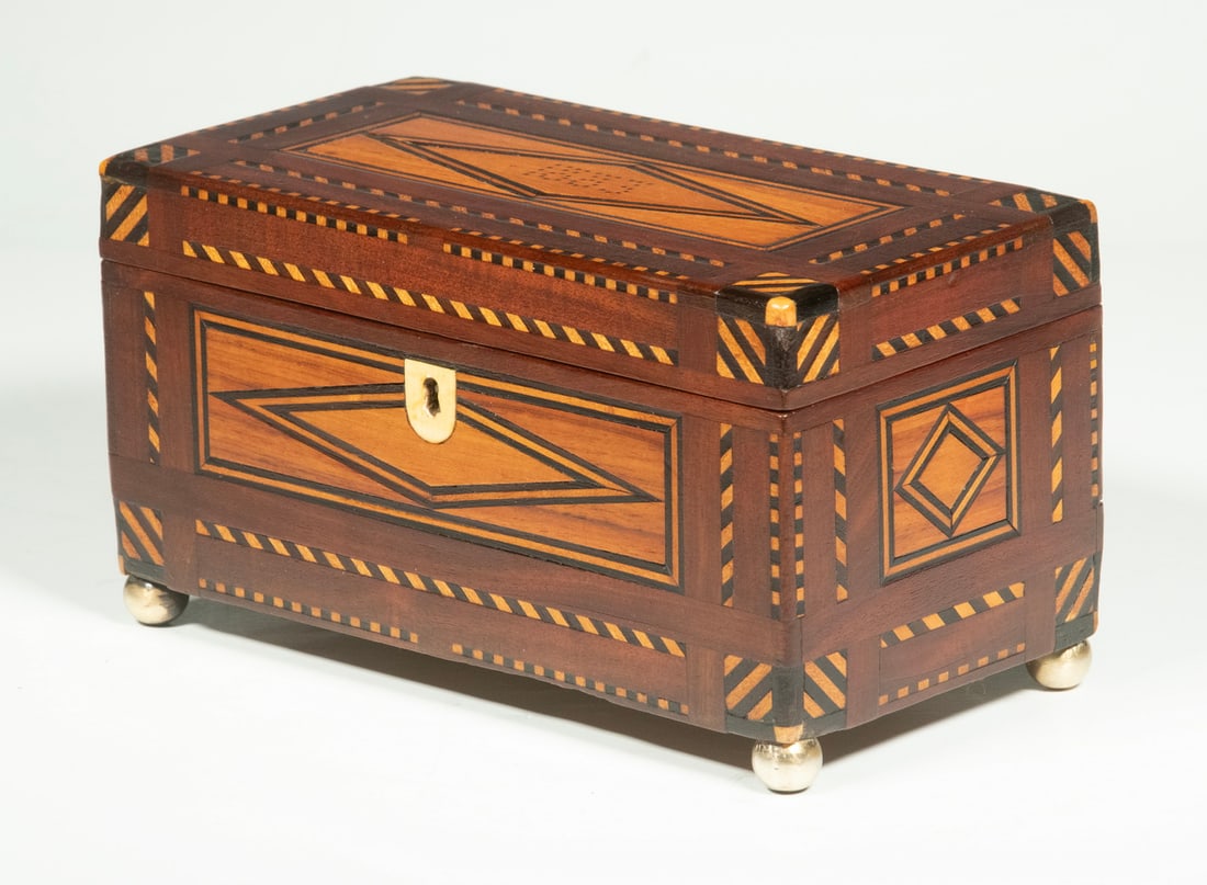 VICTORIAN INLAID MAHOGANY TEA CADDY: Rectangular Tea Box, dated 1883 on lid, with extensive parquetry decorative inlay to lid and all sides, ivory escutcheon (with key), set on metal ball form feet, two interior lidded compartments with