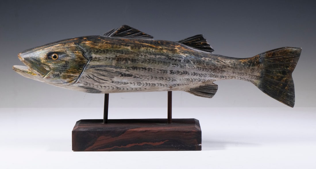 WILL E. KIRKPATRICK, JR. CARVED FISH SCULPTURE: Carved and Painted Wooden Striped Bass Figure, by Hudson, MA carver Will E. Kirkpatrick (1939- ), having a nicely formed body with glass eyes, mounted on a rectangular wooden stand, impressed "WEK" on