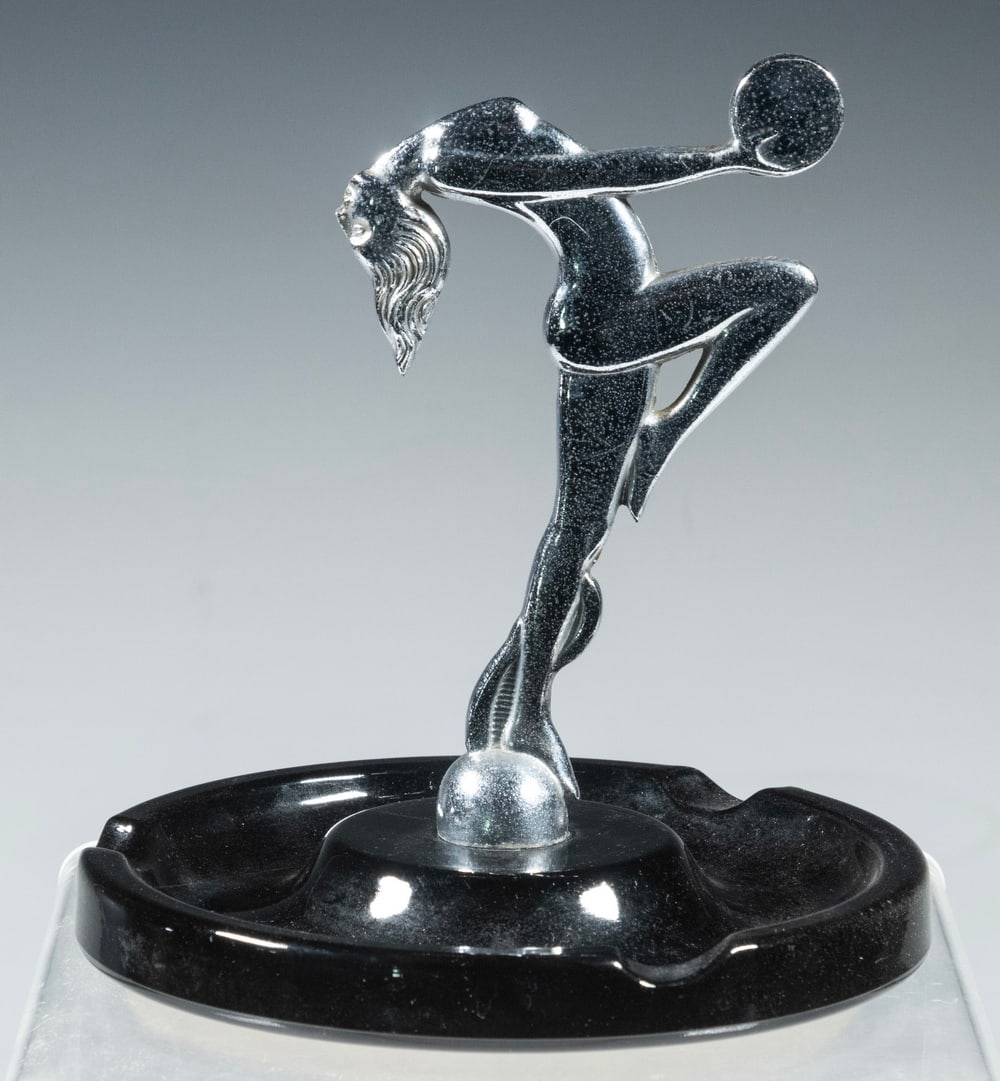 ART DECO CHROME & GLASS ASHTRAY: Circa 1920s Round Figural Ashtray, depicting a chrome finished dancing female figure atop a black glass base, felted underside, 6" high, 5 1/2" diam. Converted dimensions: 6 x 5 1/2 in. (15.2 x 14 cm.