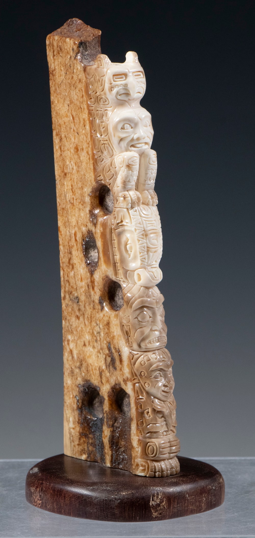INUIT MAMMOTH TUSK CARVING: Five Character totem carved from a section of a Wooly Mammoth Tusk, mounted on a hardwood base, 6 x 2" x 1/2", excluding base. Converted dimensions: 6 x 2 x 0 1/2 in. (15.2 x 5.1 x 1.3 cm.)