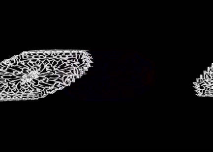 EDWARDIAN 14K GOLD AND DIAMOND BROOCH: Delicate openwork filigree 14K white gold brooch centering a single diamond in square mount, stamped; size 1" x 3/4"; 1.2 dwt. tw. Good condition. Dimensions 1 x 0 3/4 in. (2.5 x 1.9 cm.)