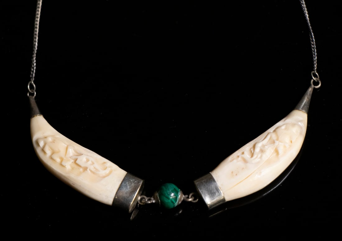 CARVED TOOTH NECKLACE: Steel Chain Link Necklace, centered with two carved animal teeth and central malachite bead, 17" long, each tooth (with mount): 2 1/2" x 1/2". One tooth cracked. Dimensions