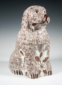 LARGE SPONGE-DECORATED POTTERY DOG WITH RELIEF FLORAL MOTIF