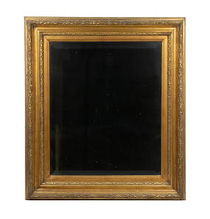 GILTWOOD BEVELED MIRROR, LATE 19TH CENTURY: Giltwood frame with incised foliate motif, housing a beveled glass mirror. The frame exhibits a warm gold finish and crisp linear carving, typical of late 19th-century transitional neoclassical and ae