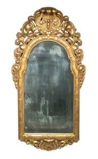 EARLY ITALIAN GILTWOOD MIRROR: Arched Top Carved Wood with deep relief scroll and shell crest and bracket, internal shallow carved domed frame, with conforming beveled glass and original backboards.From the estate of Brooke Astor a