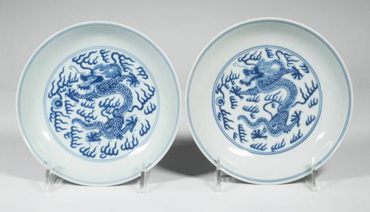 PR CHINESE BLUE & WHITE DRAGON DISHES DAOGUANG MARK: Pair of 19th c. Qing Dynasty Porcelain Dishes, 1821-1850, the interior and exterior of each with cobalt blue decoration of five-toed dragons in pursuit of a flaming pearl, set on a low foot, each base