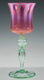 TIFFANY STUDIOS PASTEL FAVRILE ART GLASS GOBLET: Delicately hand-blown goblet featuring a flaring pink and violet iridescent bowl, above a baluster-form stem with clear green nodes and a circular foot. Signed L.C.T. Favrile to the underside. 7 7/8"