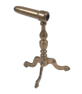 18TH C ENGLISH BRASS CURLING IRON STAND: Cast brass curling iron stand with turned shaft and three splayed feet, featuring a hollow socket arm designed to cradle a heated styling tool. 6" Height. OS: 6 in. (15.2 cm.)